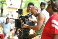 sudhanshu saria - Filmmaker using a professional video camera on an outdoor set, surrounded by crew members.
