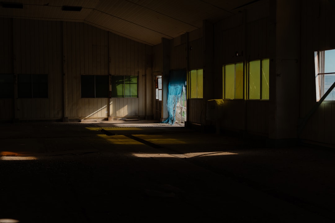 Sunlight streams into an empty, dimly lit room.