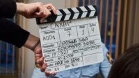A clapperboard held on a short film set, marking a shot in production.