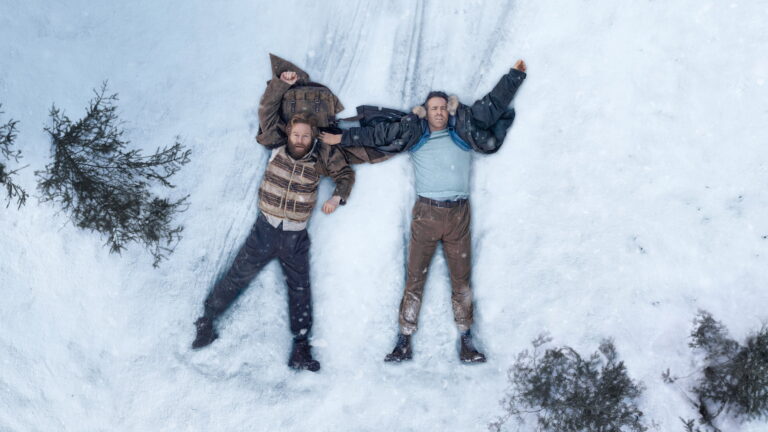 Mayday: Reynolds and Branagh Are the Best Duo of the Year 7 Ryan Reynolds and Kenneth Branagh lying in the snow in Mayday