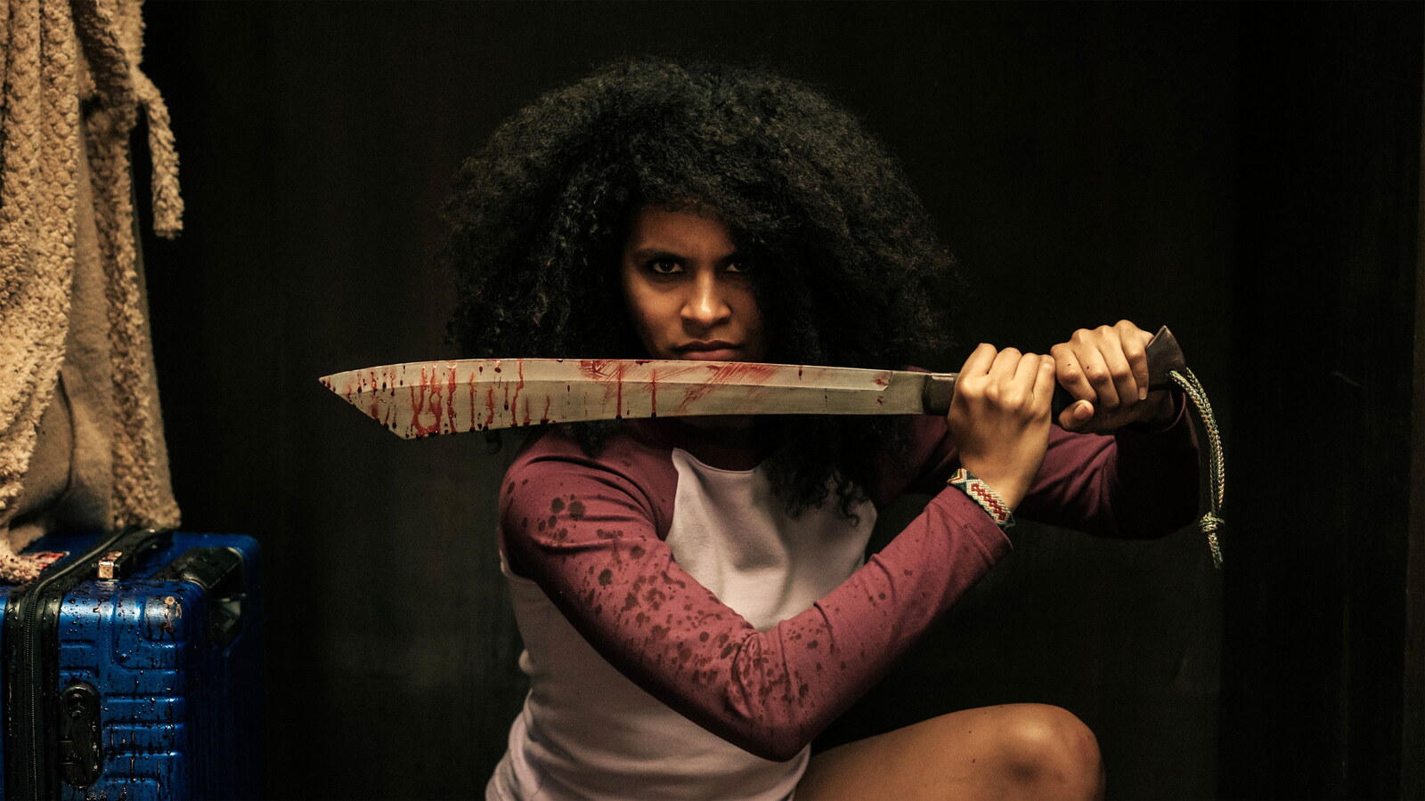 Asia holds a blood-smeared blade in They Will Kill You